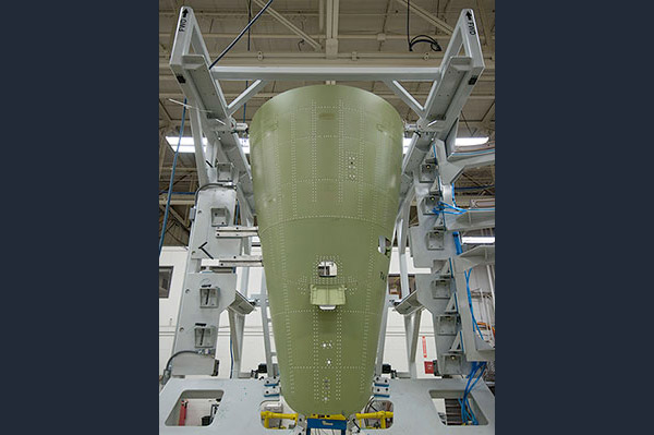 The upper tail cone is also assembled in a vertical jig for precise manufacturing. In the center of this image  is where the vertical stabilizer joins the fuselage.