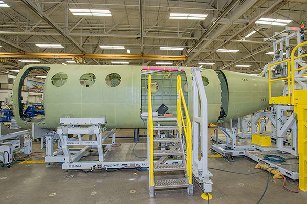 Here the center section is being joined to the tail cone in the fuselage mate tool. Soon the cockpit and nose will be added forward of the entry door to complete the main fuselage and get it ready to have its wings installed.